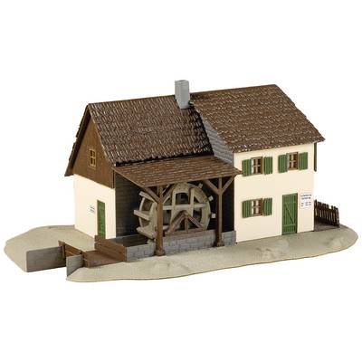 Model of a traditional house with a waterwheel. Building detail with chimney and green window shutters. House on a small plinth.