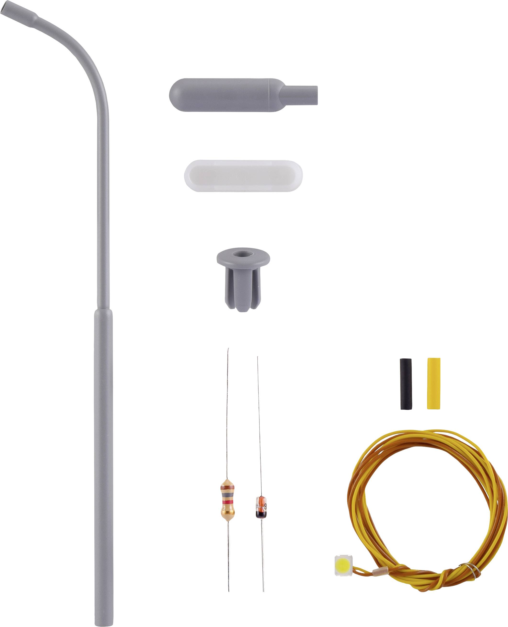 A set of soldering iron components: a grey soldering scraper, two resistors, yellow cables, and various plastic parts for assembly.