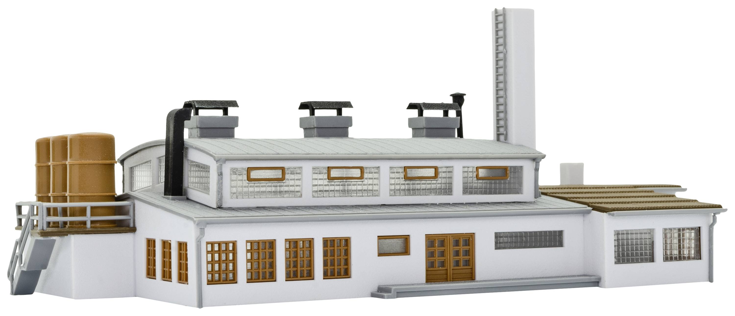 A small factory building with white walls, several chimneys, and a large water tank on its side.