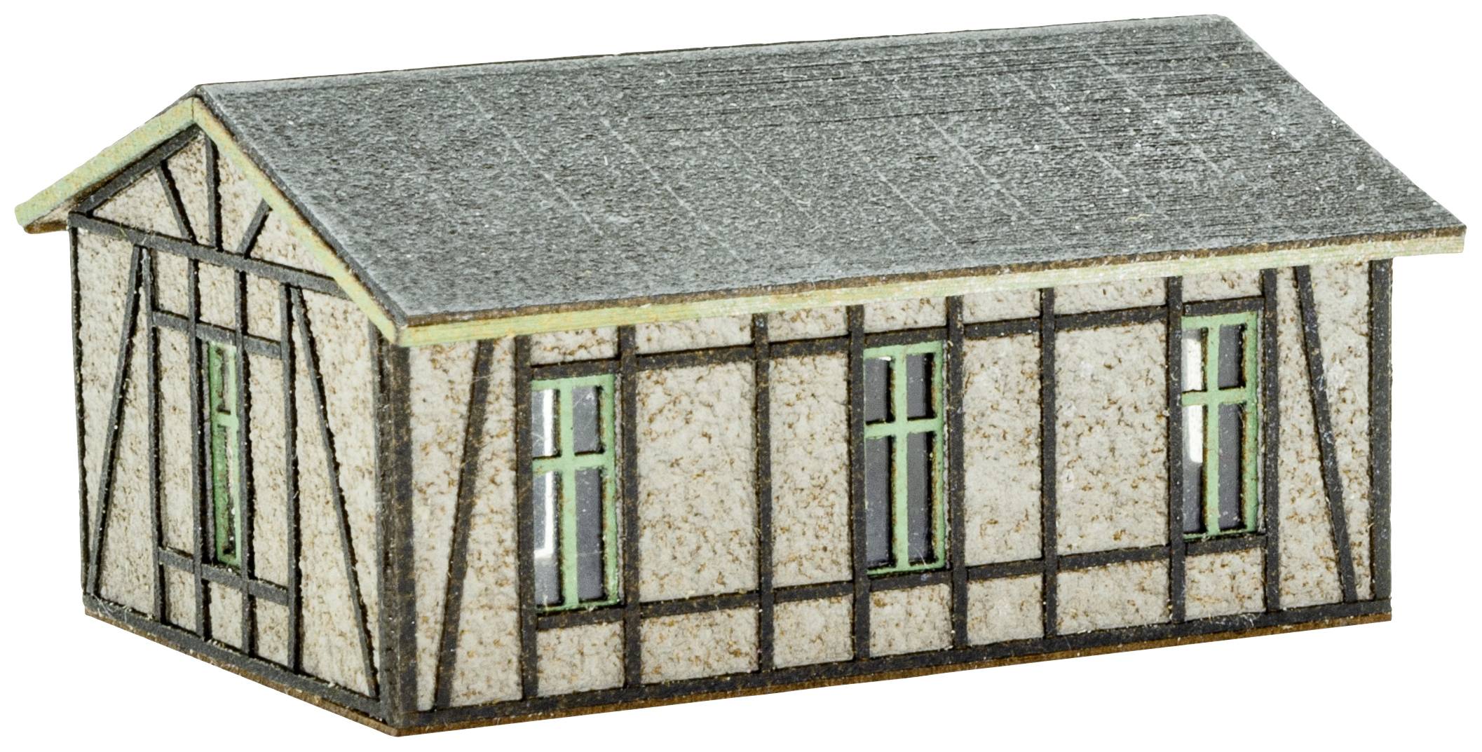 A small model of a half-timbered house with a grey roof and green windows, without any visible surroundings or additional details.
