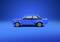 Blue car in profile against a blue background. Classic design with two doors and a prominent rear spoiler. Vehicle is stationary.