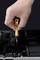 A hand is holding a yellow screwdriver and is unscrewing an open laptop. Components and battery are visible.