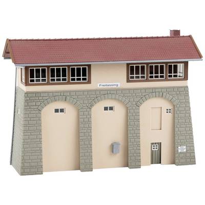 A model of a signal box with the inscription 'Freilassing'. The building has a red pitched roof, stone arch walls, and several windows.