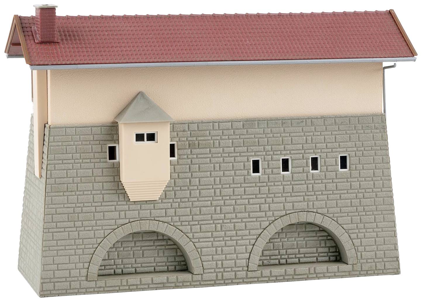 A model of a medieval building with a red pitched roof, brick arches, and small rectangular windows.