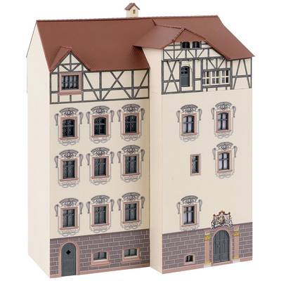 Miniature model of a historic half-timbered building with multiple windows and intricate decorative details against a beige background.