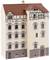 Miniature model of a historic half-timbered building with multiple windows and intricate decorative details against a beige background.