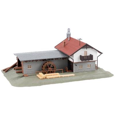 Model of a sawmill: Building with a red roof, water turbine on the side, and stacked tree trunks in the yard.