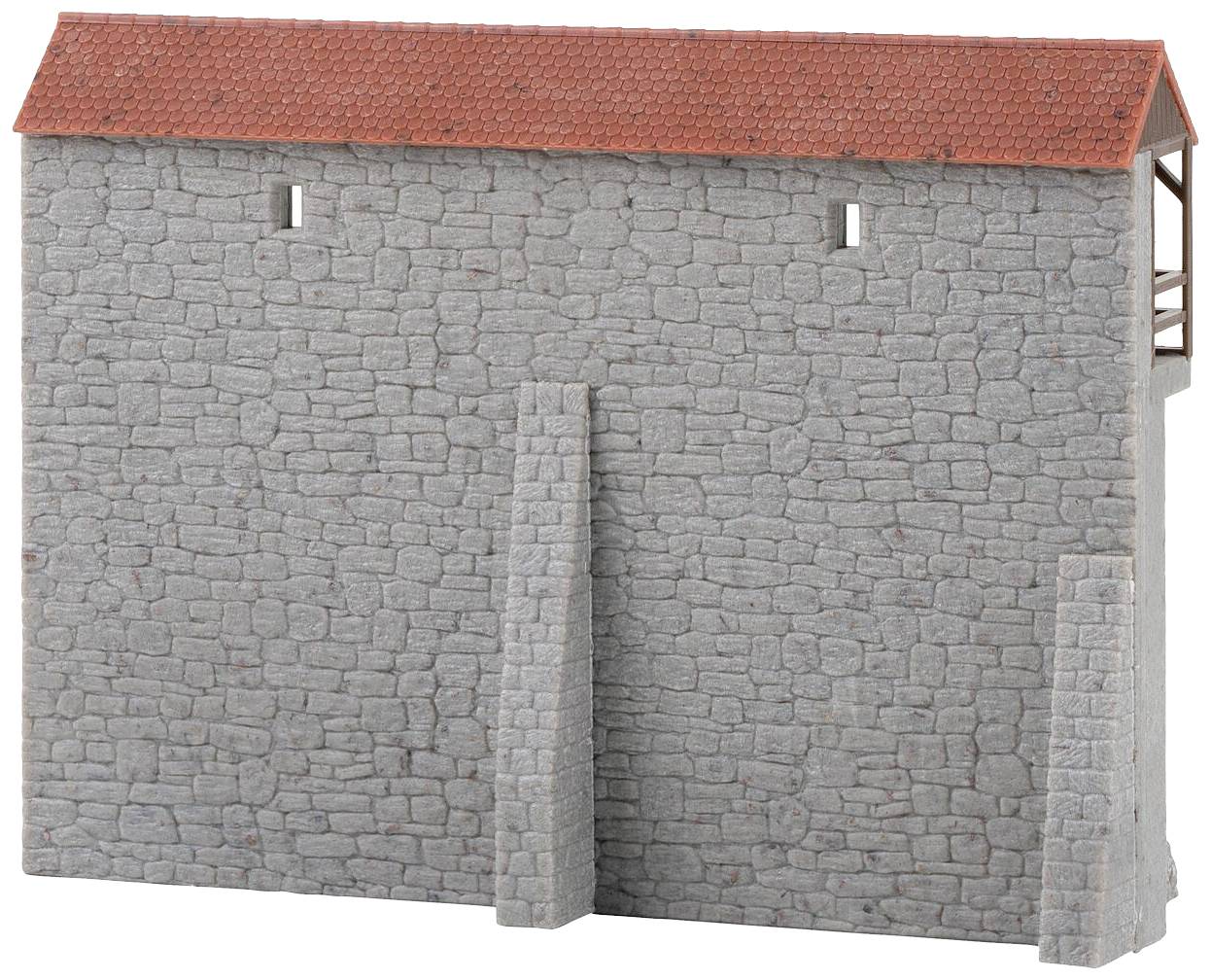 Grey stone wall with a sloping, red tiled roof and two small, rectangular windows.