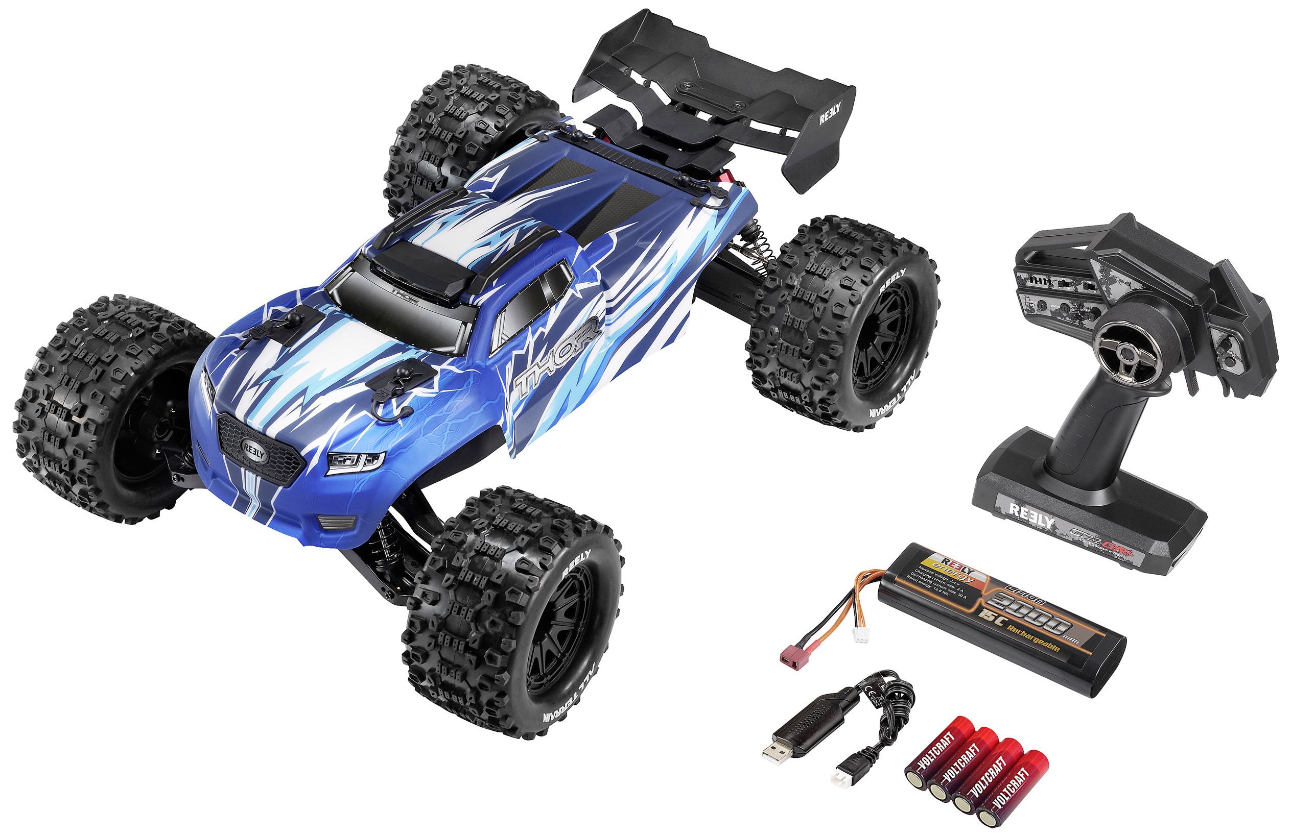 Blue remote-controlled car with large tyres, remote control, rechargeable battery, charger, and batteries. Ideal for outdoor racing.
