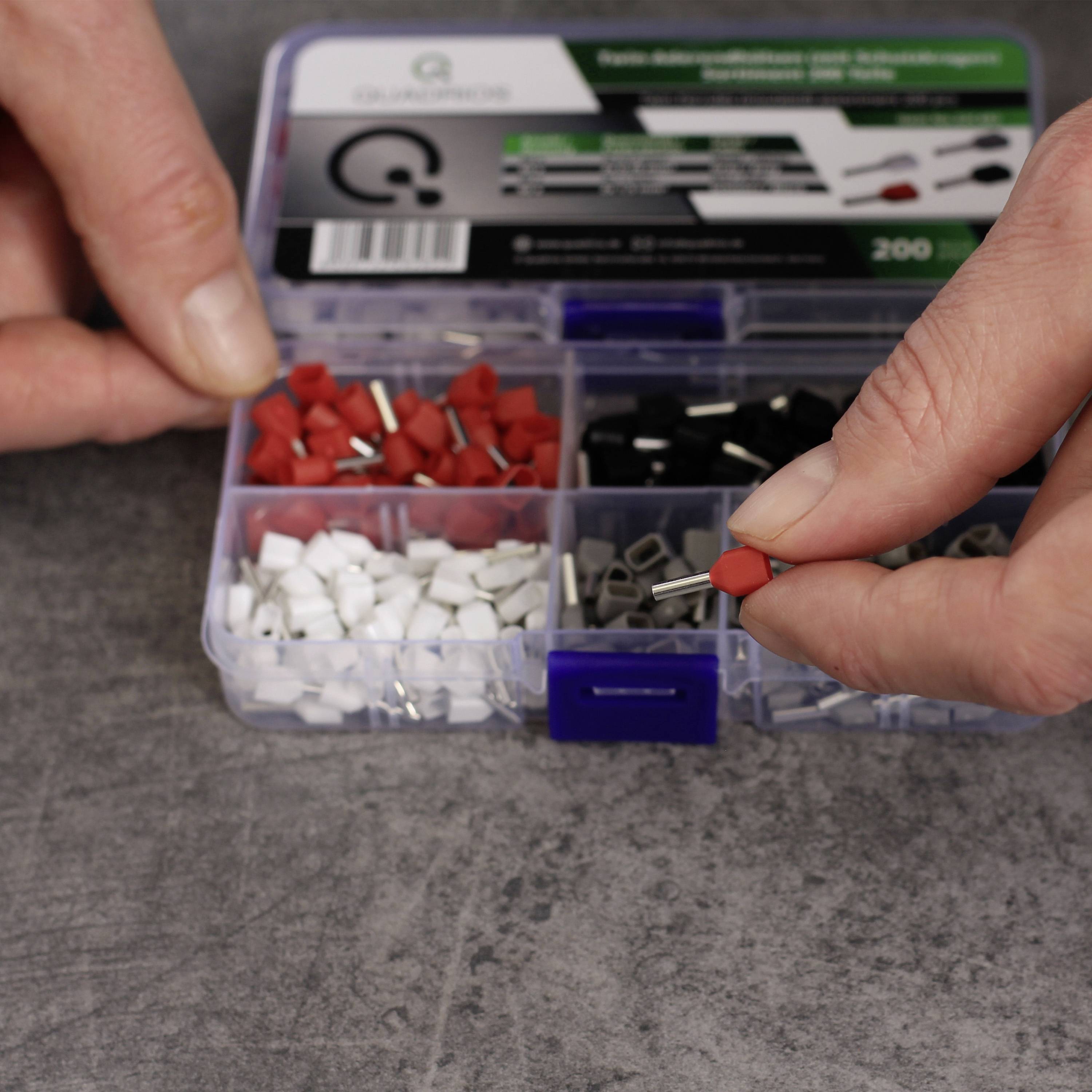 A person is holding red tablecloth weights from a box containing weights in various colours, including white and black. Table decoration is visible in the background.