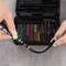Two hands are holding a screwdriver and a cable. In the background, an open toolbox with colourful bits can be seen.