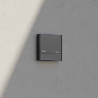Electrical installation mounted on a concrete wall, rectangular in shape, dark grey, with brand name visible.