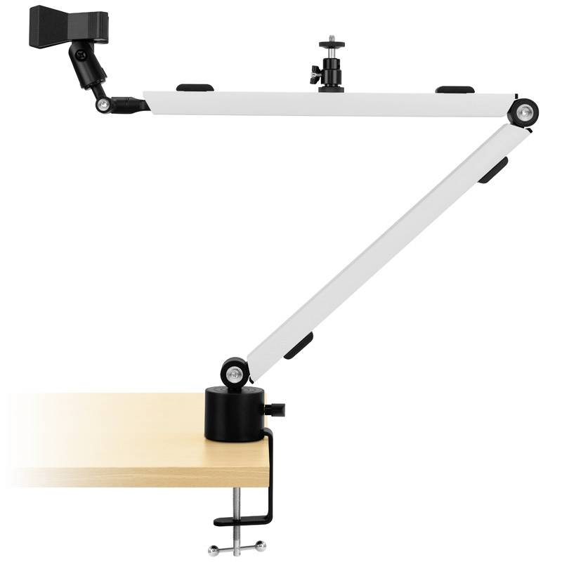 An adjustable monitor arm is attached to a wooden desk. The arm has joints for flexible adjustment of the monitor position.