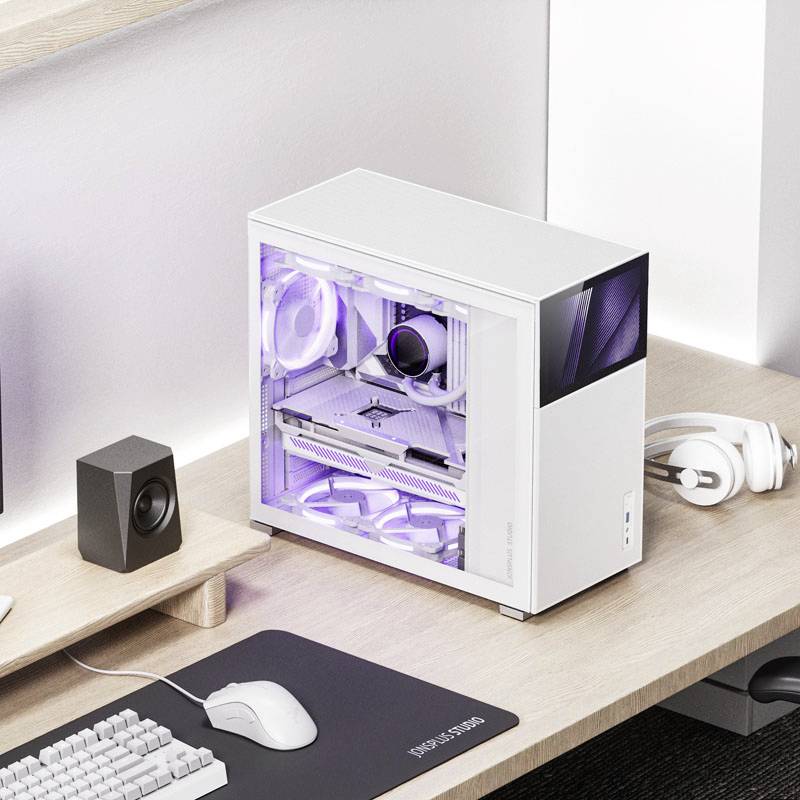 White computer station with a transparent case shows illuminated fans. Speakers, keyboard, and mouse are placed on a wooden desk.
