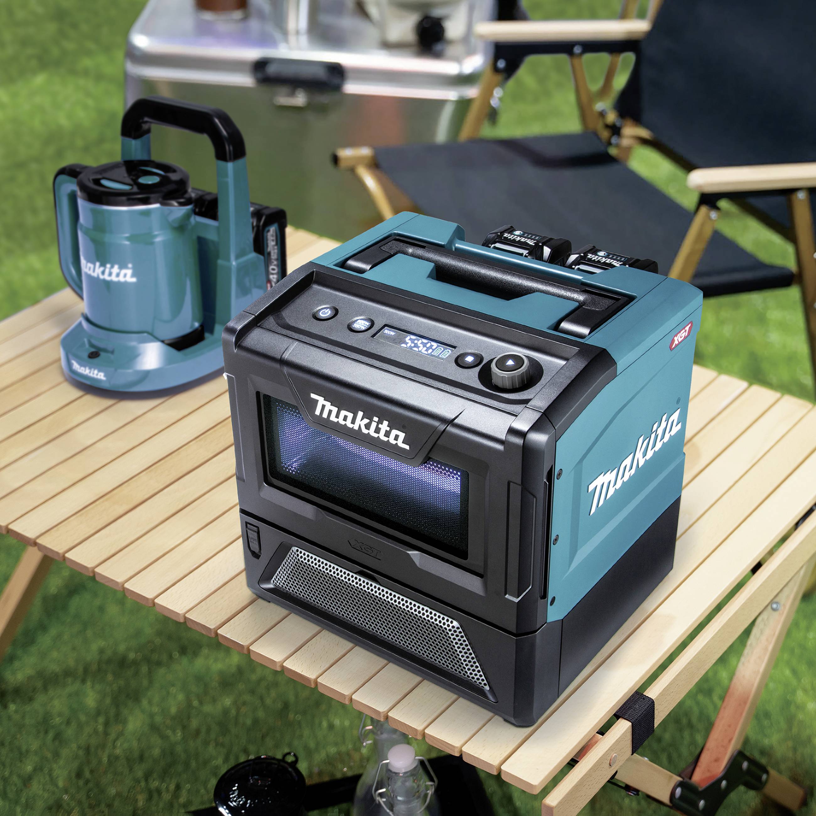 A portable, cordless speaker from Makita sits on a camping table outdoors. Next to it stands a Makita coffee machine.