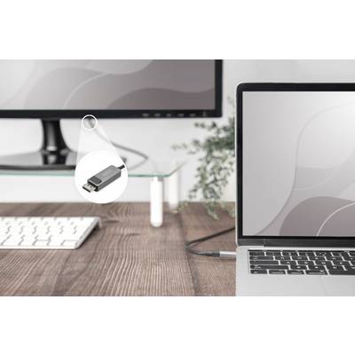 A laptop and a monitor are connected with a USB-C adapter. The adapter is lying on a wooden table next to a keyboard.