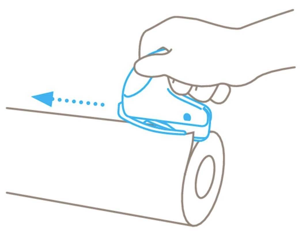 A hand holds a device sliding over a roll of paper. An arrow indicates the direction of movement.