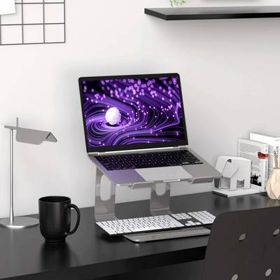 A desk with a laptop on a stand. Next to it, a mug, lamp, and office supplies. The laptop displays a purple pattern.