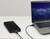 An external hard drive is connected to a laptop via a USB cable. A night sky is visible on the laptop screen.