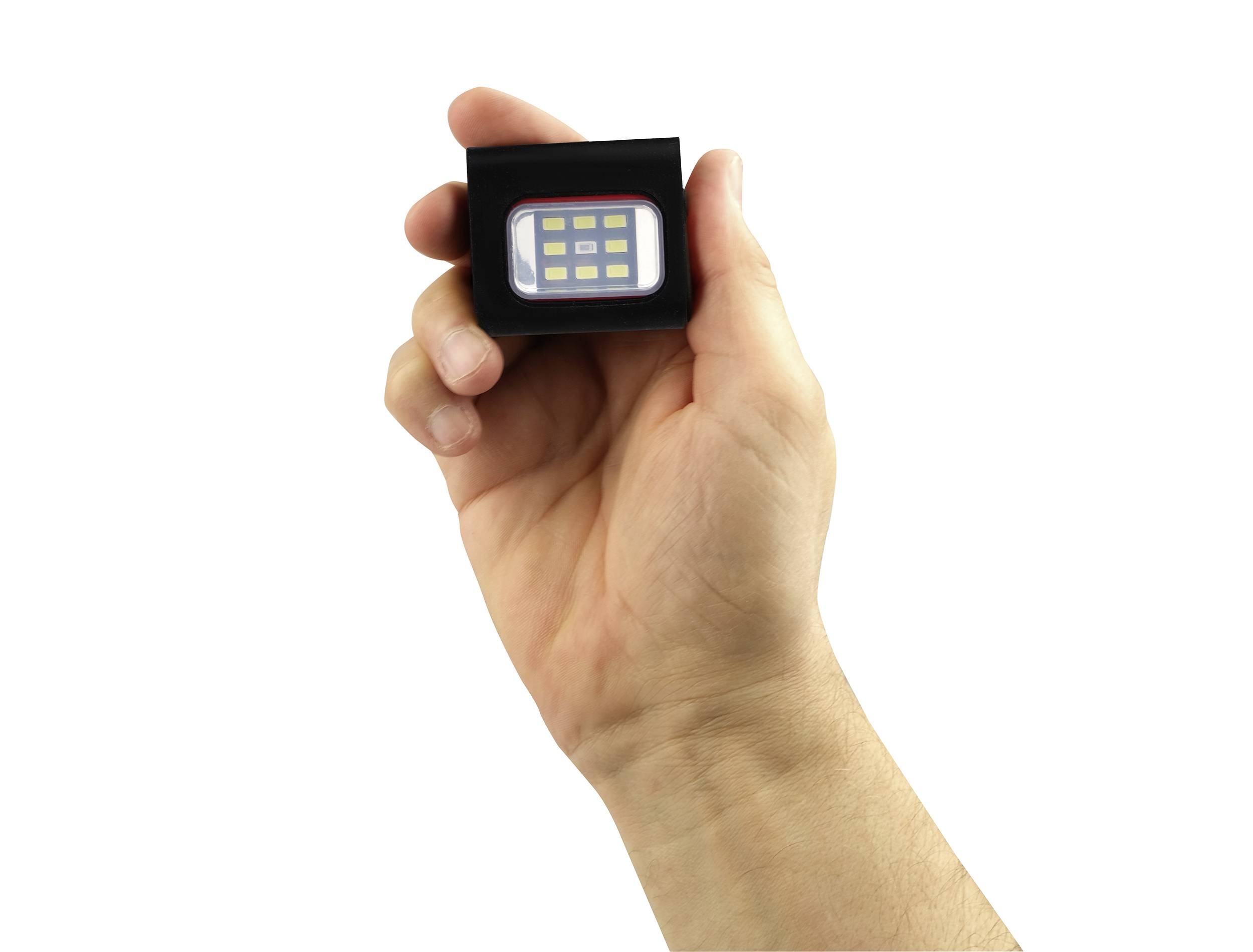 A hand is holding a small, rectangular LED light with multiple yellow diodes in a black casing.