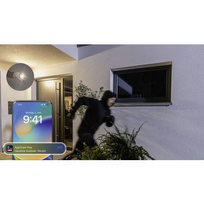 A masked person is running away from a house at night. Next to the image is a smartphone screen displaying an alarm notification.