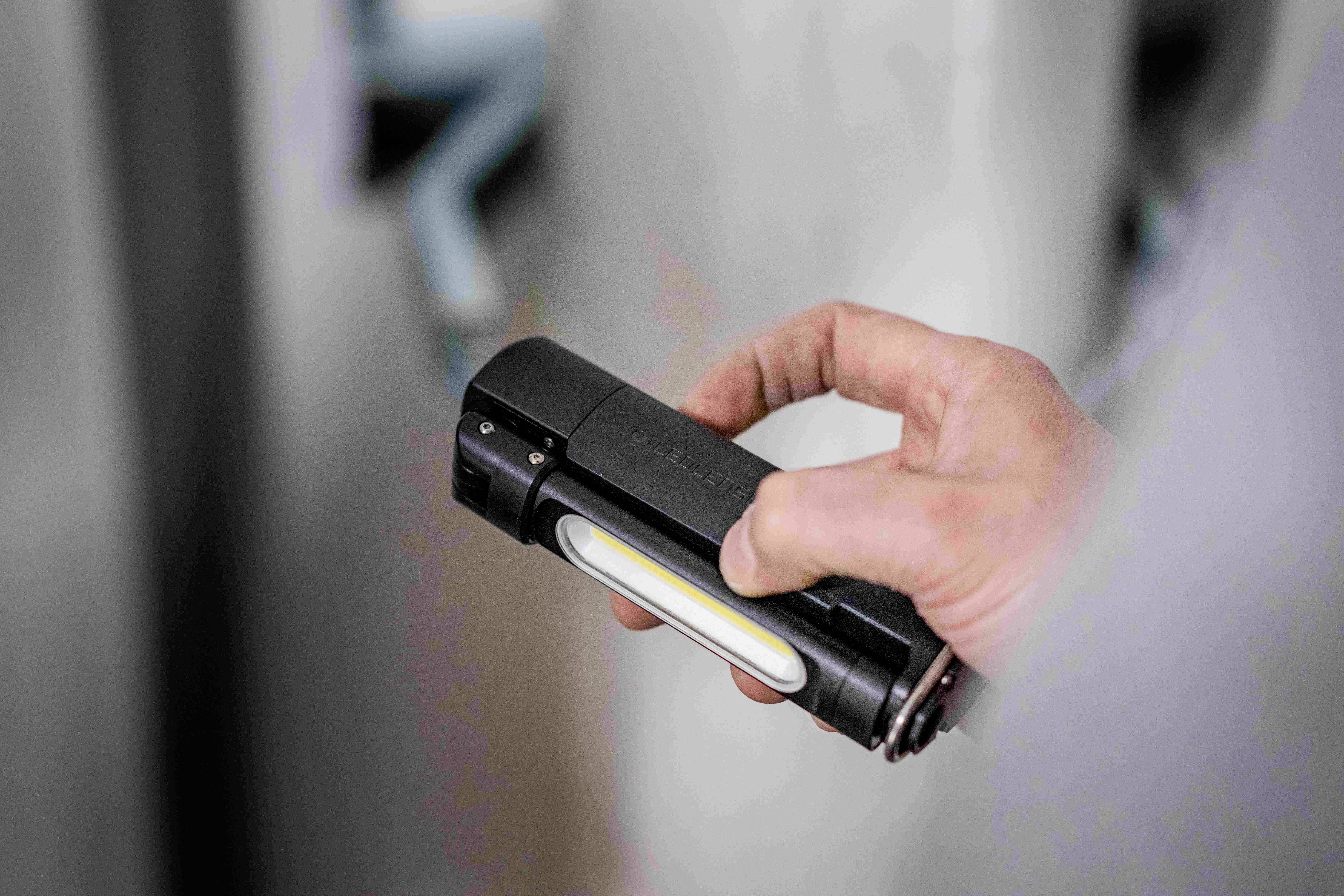 A hand is holding a black torch.