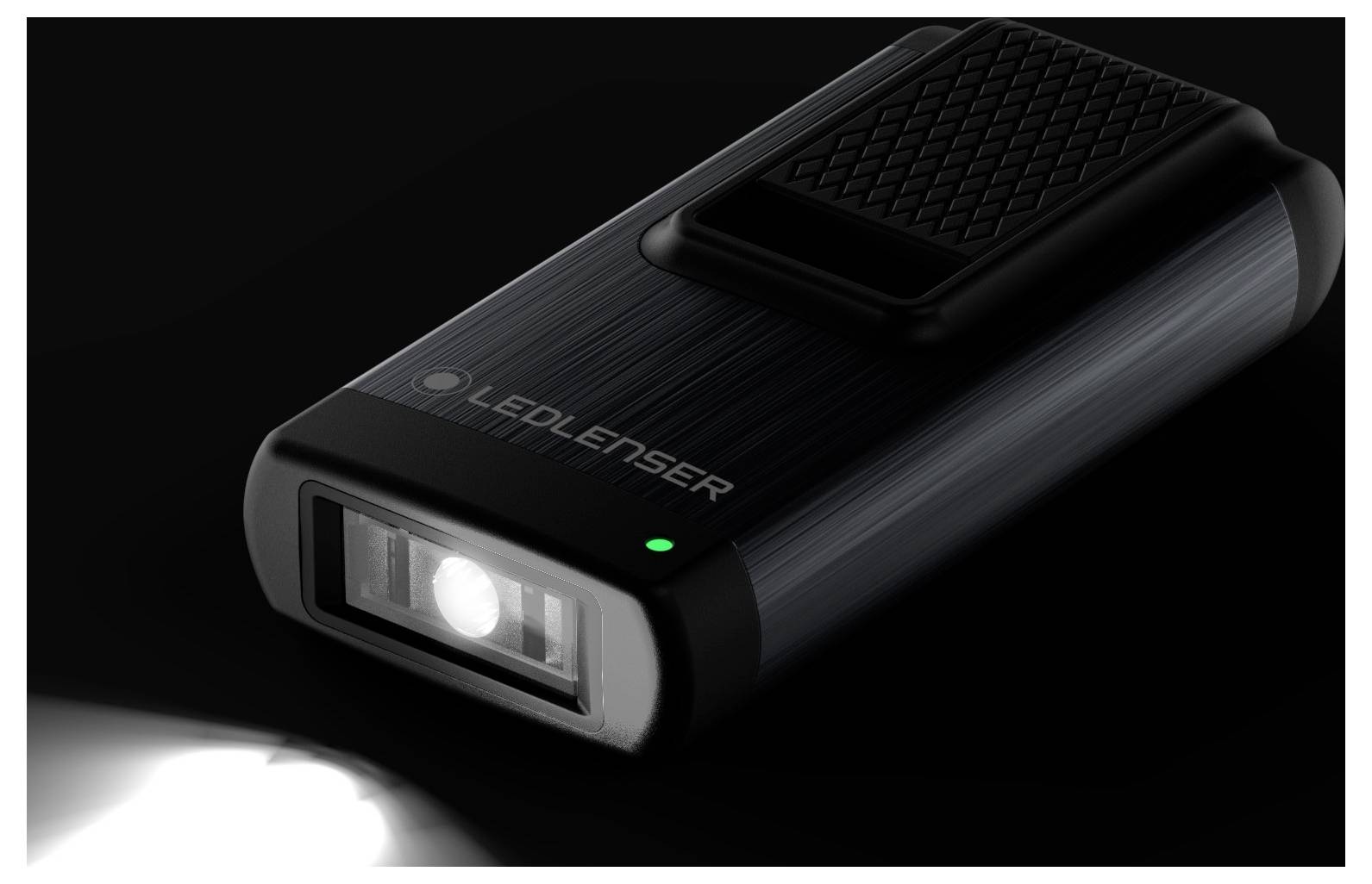 Compact, black LED torch with a bright front light and green control indicator, displayed against a dark background.