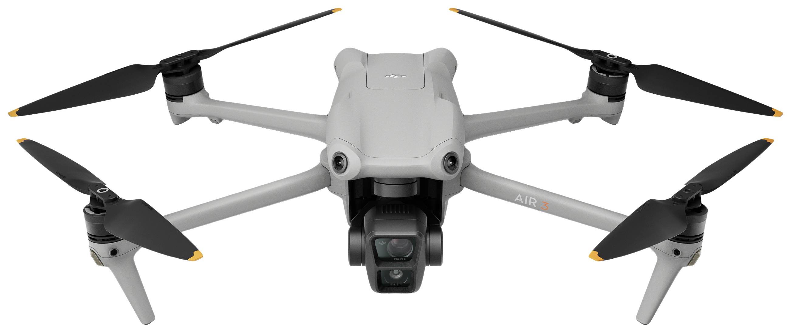 Grey drone with four propellers and a camera on the front. It is standing against a white background.