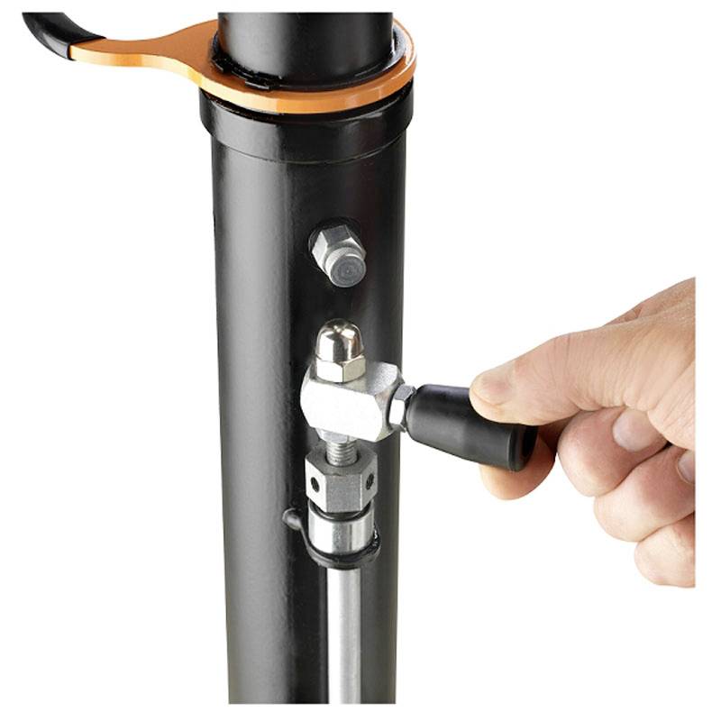 A hand adjusting a valve on a black metal pipe, demonstrating control or maintenance of a mechanical component.