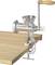 'Manual meat mincer, made of metal, with a wooden handle, attached to a wooden surface.'