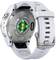 Rear view of a sports watch with a circular sensor glowing green. Strap in white.