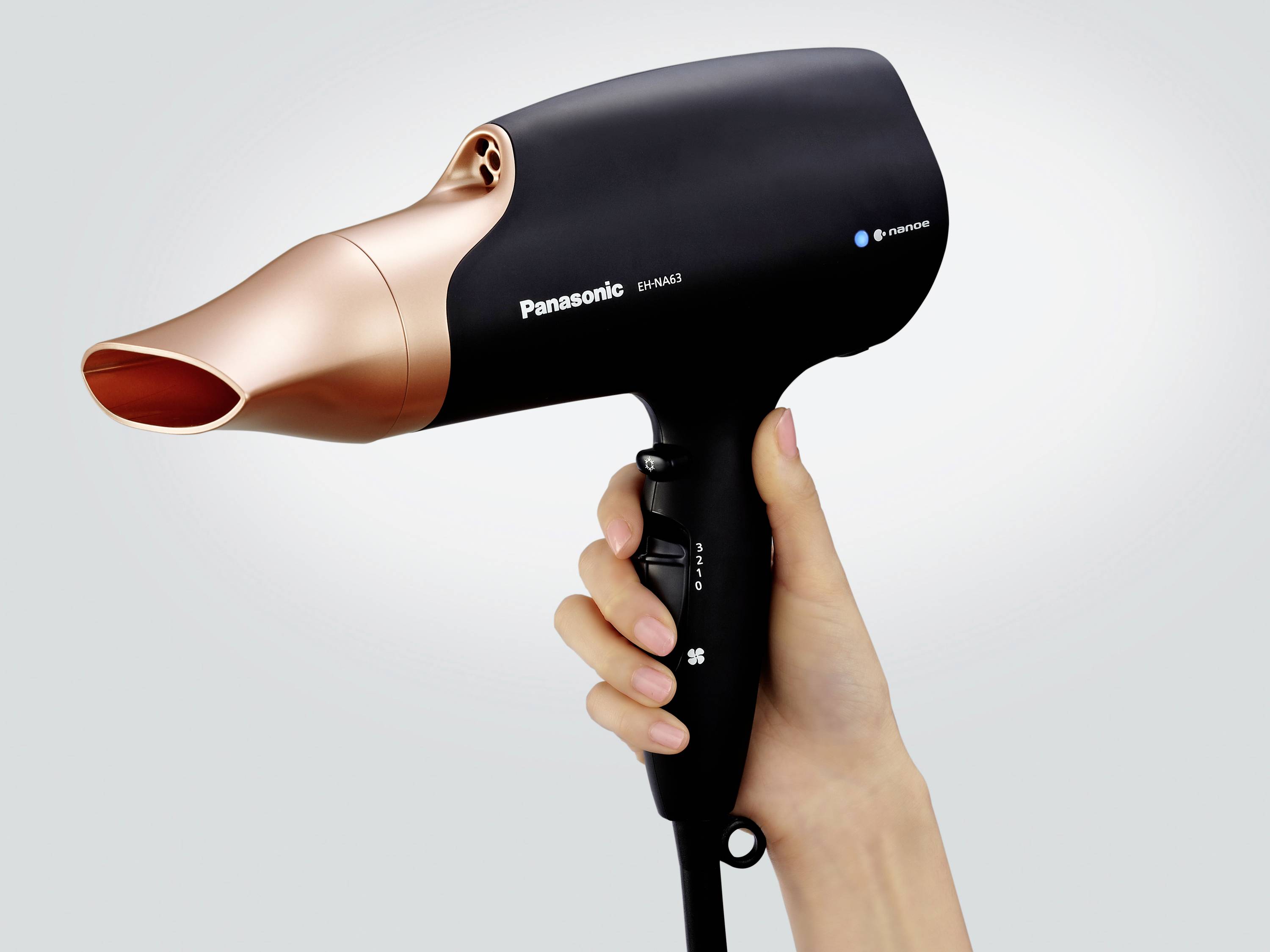 A hairdryer is being held in one hand, featuring a black and gold design. The brand name 'Panasonic' is visible.