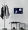 Coat stand with jackets and a pinboard on the wall displaying 'Have a Nice Day' and a photograph, with black stools beside it.