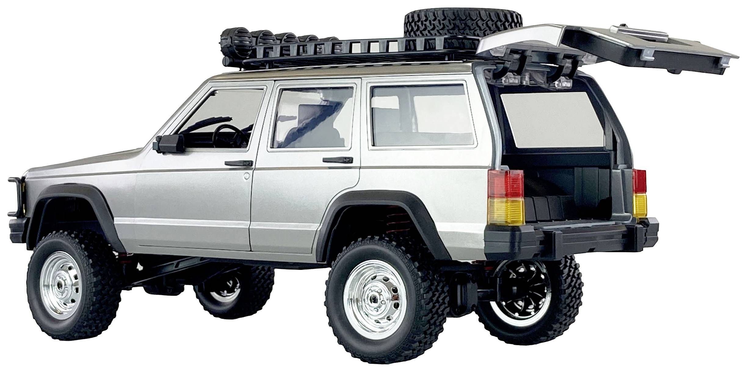 A silver off-road vehicle with raised ground clearance, roof rack and spare wheel, is standing with its boot open.