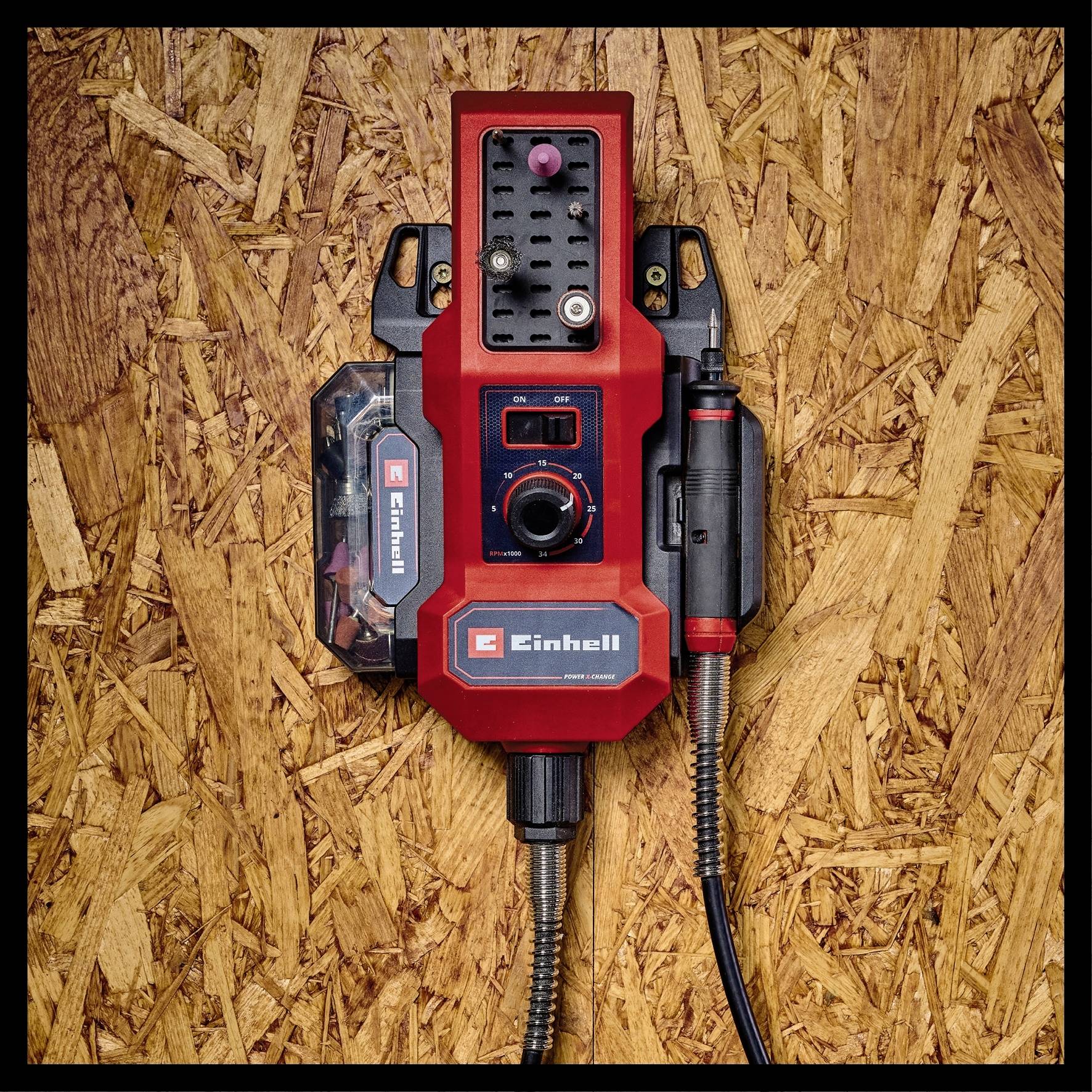 A red electric power tool mounted on a wooden board, with a black button and logo. Suitable for screwing and drilling tasks.
