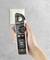 A hand holds a voltage meter in front of a socket to check electrical properties.