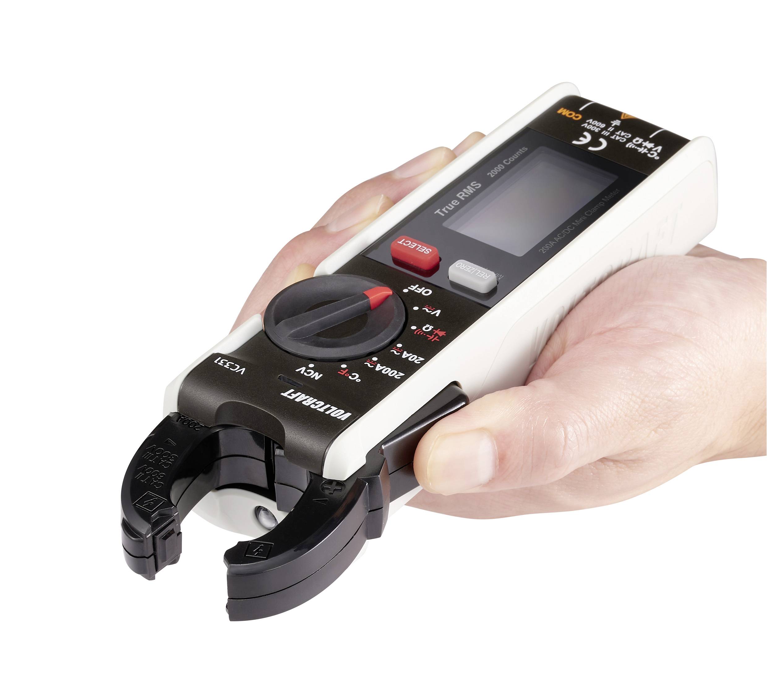 A hand is holding a digital ammeter with an open hinged clamp. The device displays measurement values on a screen and has multiple operation buttons.