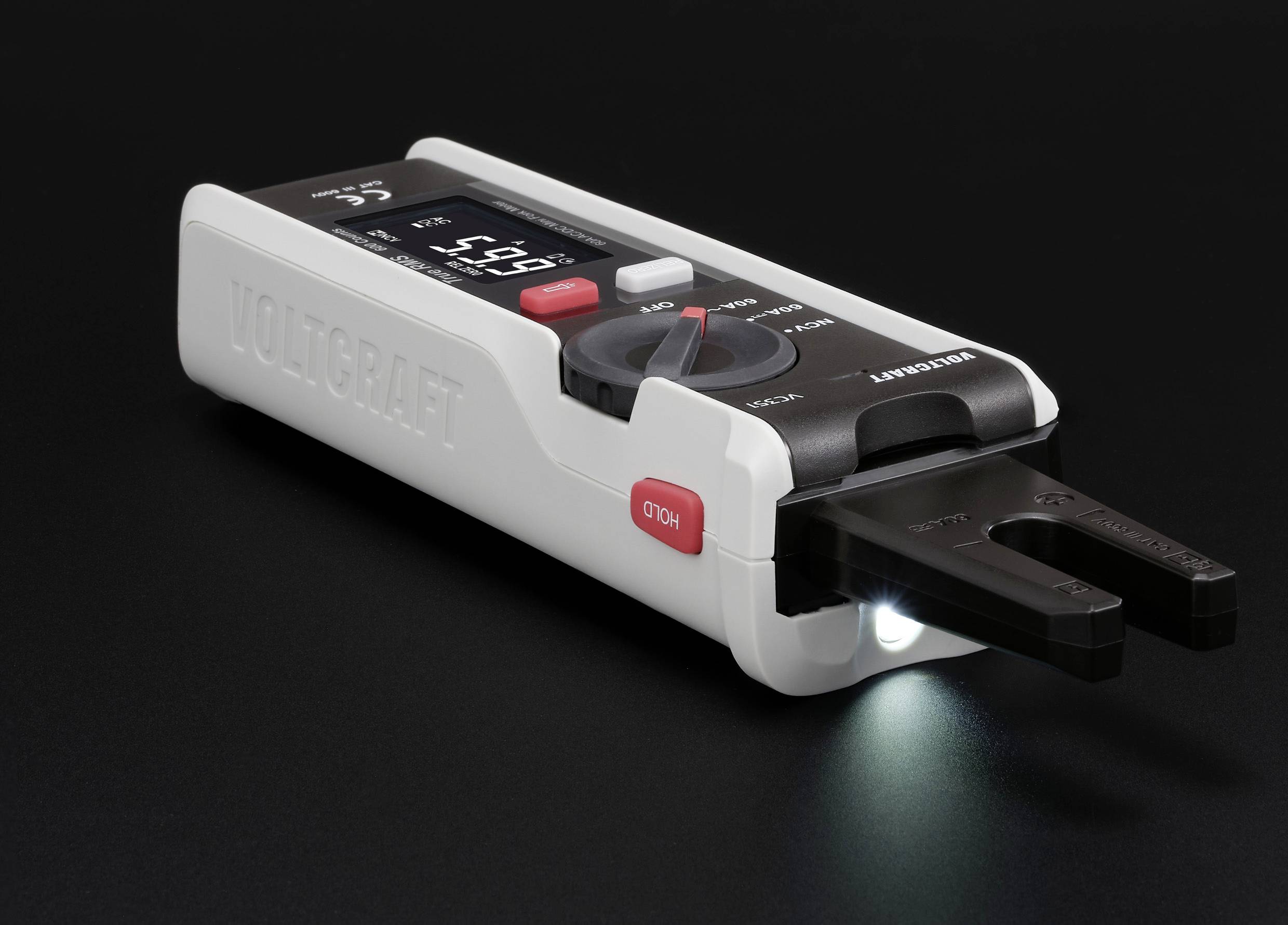 A digital voltage tester with an illuminated display shows '5.91 V'. The device is resting on a dark surface.