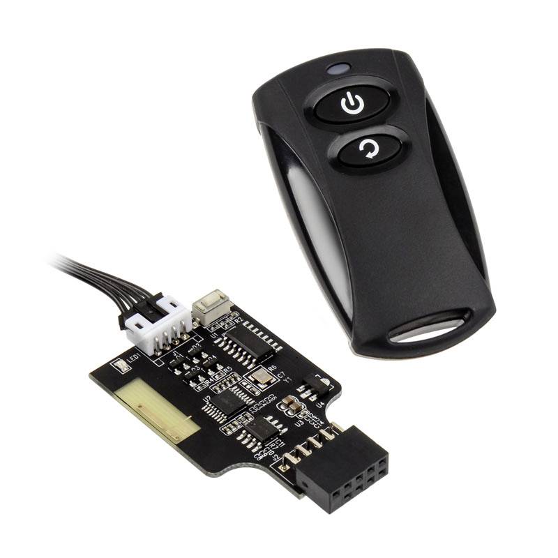 A black, wireless remote control transmitter with two buttons lies next to a small electronic circuit board with connecting cables.