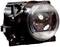 A single round car headlight in a black housing, photographed from the front. The headlight has reflective elements.
