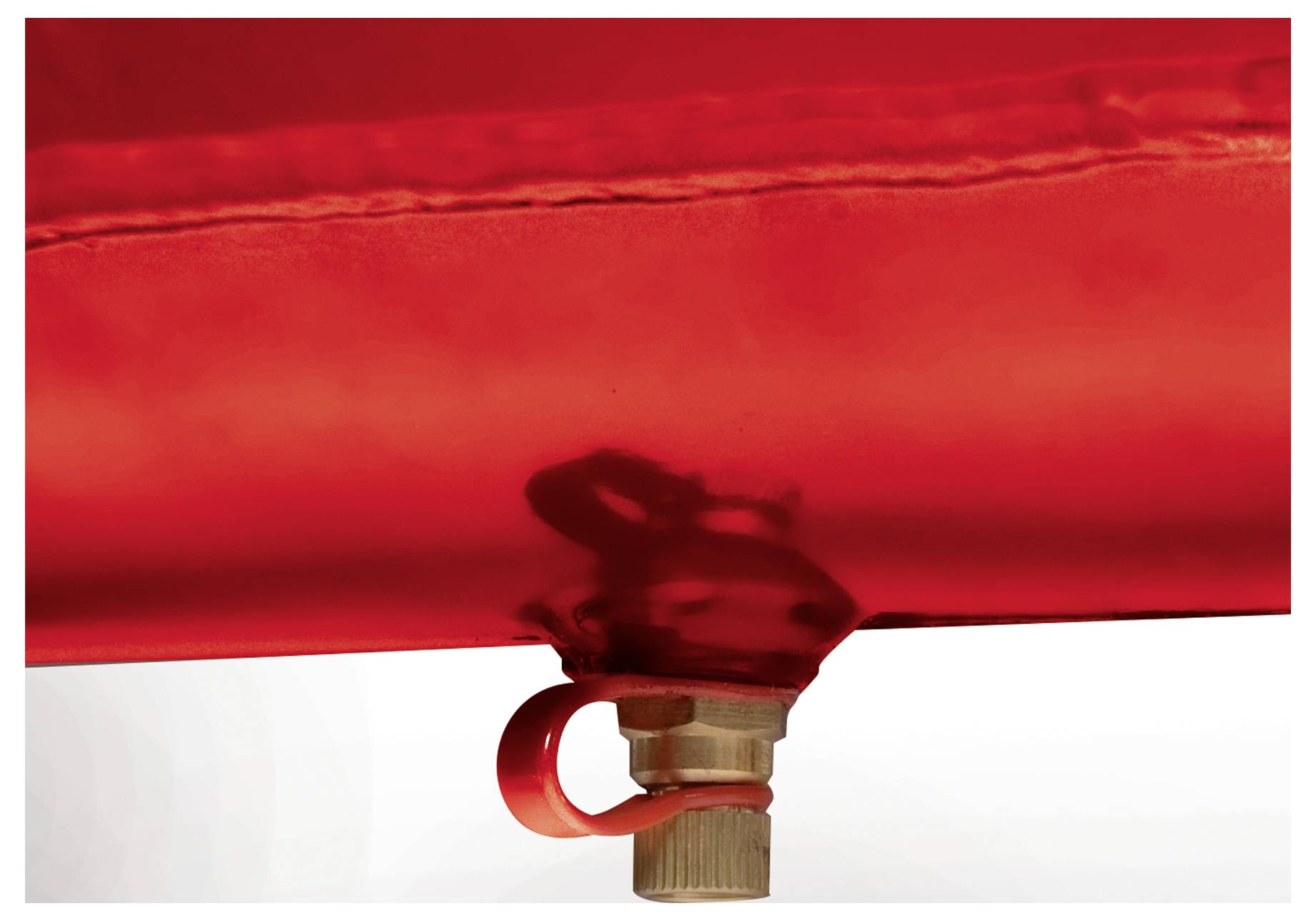 Close-up of a red translucent bag or container with a valve and red pull ring at the bottom against a white background.