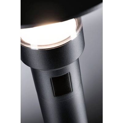 A contemporary floor lamp in close-up, emitting soft light. The lamp has a minimalist, black metal body.