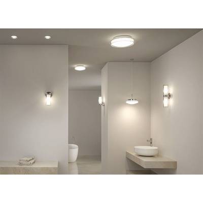 Modern bathroom with stylish lighting, washbasin unit with sink on the right, freestanding bath in the background.