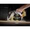 A hand holds a yellow DeWalt circular saw cutting wood. Sawdust flies, the cut is precise and clean.