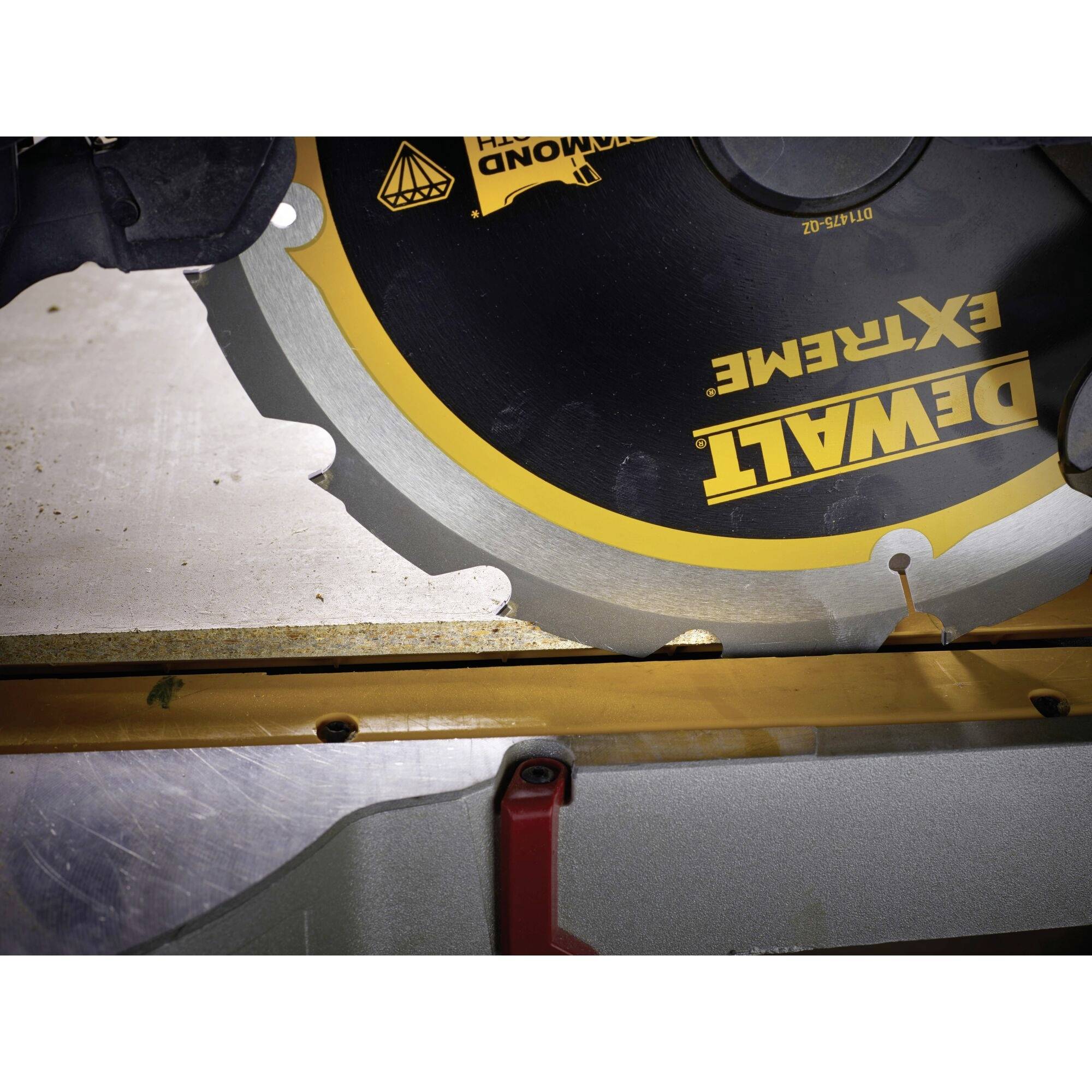A circular saw is cutting a piece of wood. The saw has black and yellow labelling and is being operated by a person.