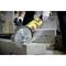 A person is sawing concrete blocks with a yellow circular saw. They are wearing gloves for safety.
