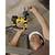 A person wearing a hard hat is working overhead on a ceiling with a yellow hammer drill, seemingly drilling into concrete.