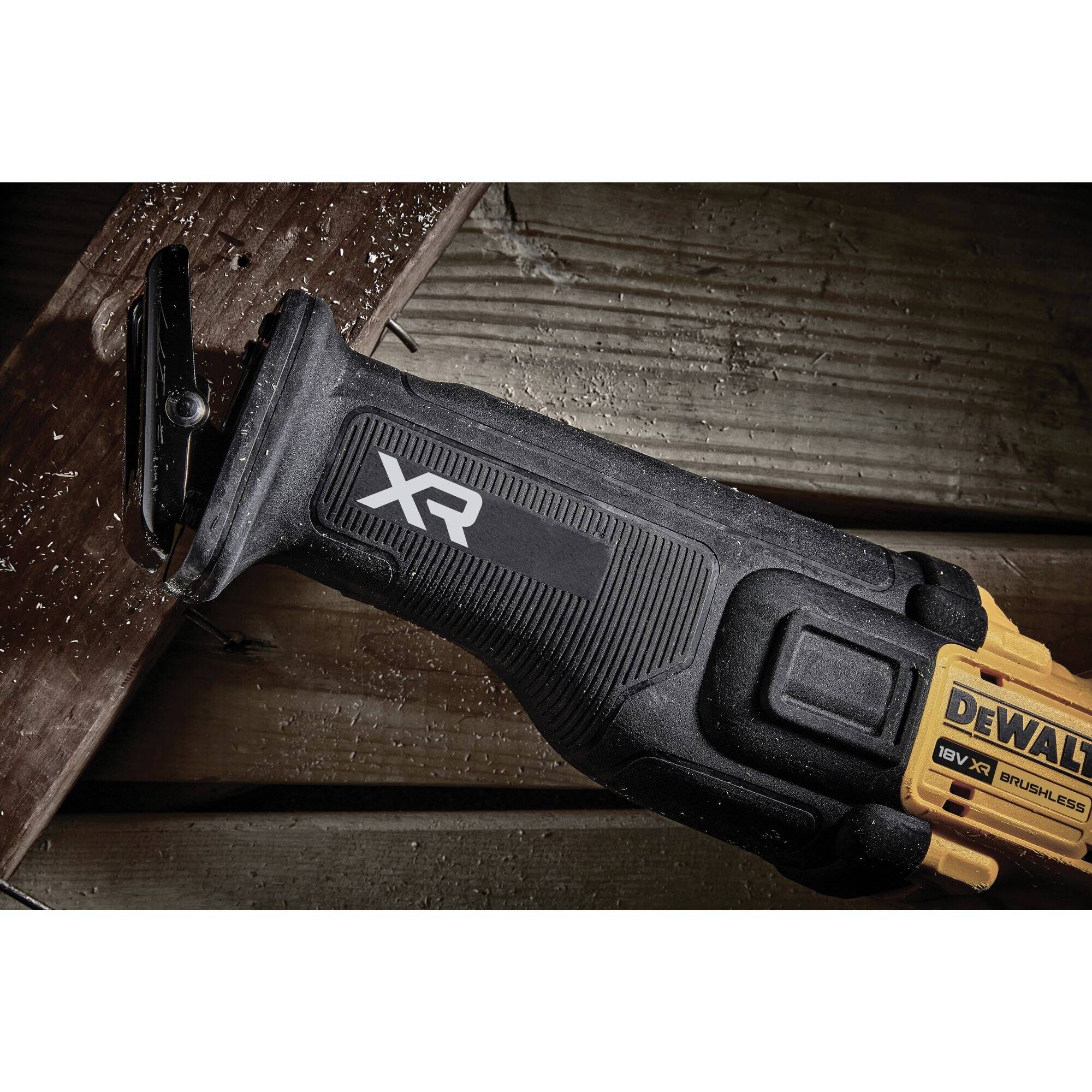 An electric reciprocating saw cuts through a wooden board. The handle displays the 'XR' logo.