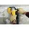 A person is grinding a concrete surface with an angle grinder. Gloves protect the hands while dust is being extracted.