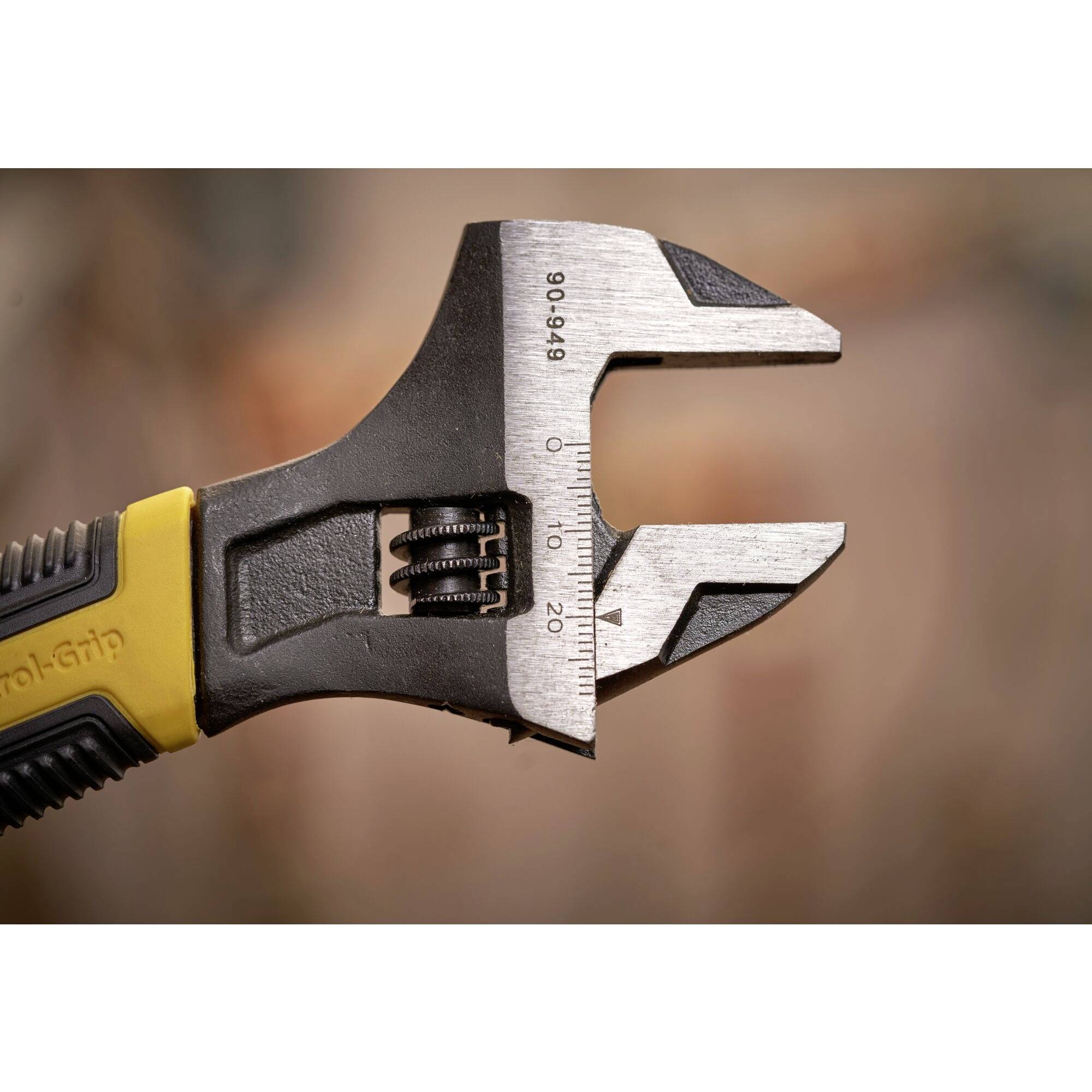 A close-up of an adjustable spanner, partially open, showing the scale for measuring the size of nuts or bolt heads.